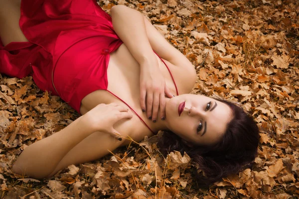 Dívka v červených šatech v podzimním lese — Stock fotografie