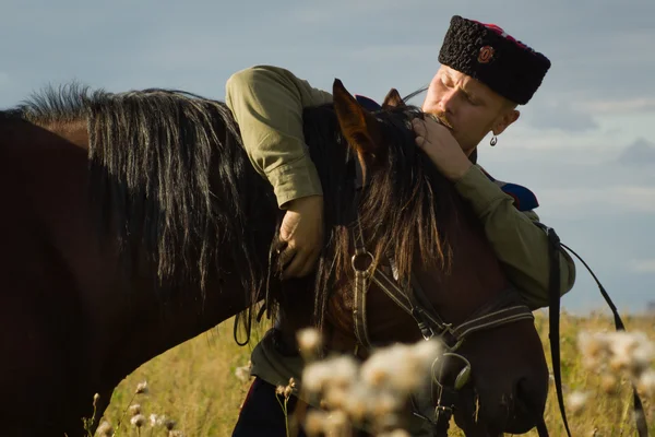 Russian Cossack with a horse resting in the summer field — Stock Photo, Image