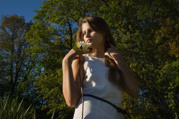 Vacker ung flicka med en vit näckros i hennes hand — Stockfoto