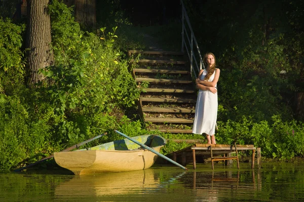 Χαλαρωτικό νεαρή γυναίκα σε ξύλινη προβλήτα στη λίμνη — Φωτογραφία Αρχείου