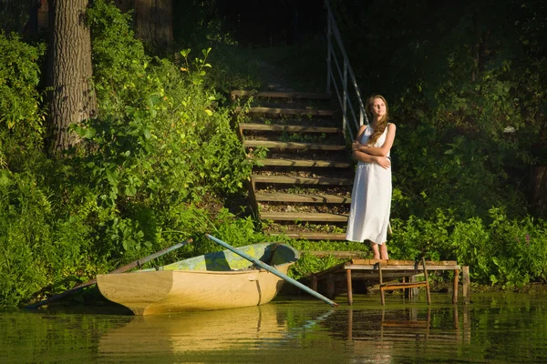 Relaxační mladá žena na dřevěném molu u jezera — Stock fotografie