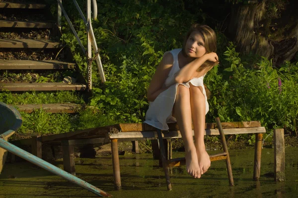 Genç kadın gölde ahşap iskele üzerinde rahatlatıcı — Stok fotoğraf
