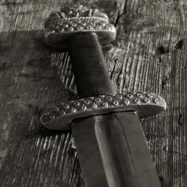 Középkori viking kard ellen egy fából készült fal — Stock Fotó