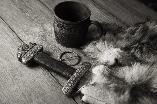 Vikingasvärd och stein på en päls — Stockfoto