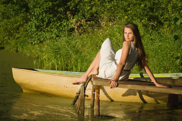 Junge Frau entspannt auf Holzsteg am See — Stockfoto