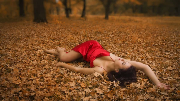 Mädchen im roten Kleid im herbstlichen Wald — Stockfoto