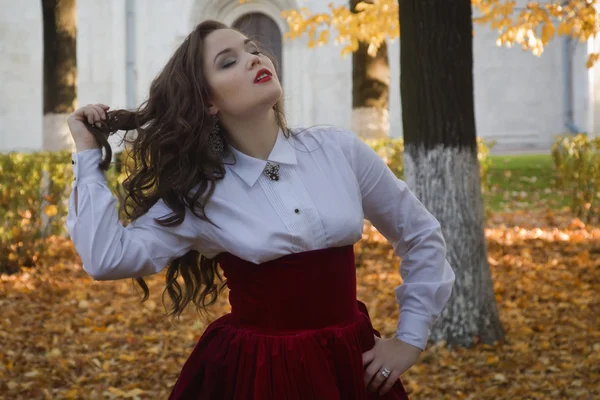 Mujer vestida en un estilo retro en el callejón de otoño — Foto de Stock