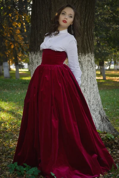 Mulher vestida em um estilo retro no beco de outono — Fotografia de Stock