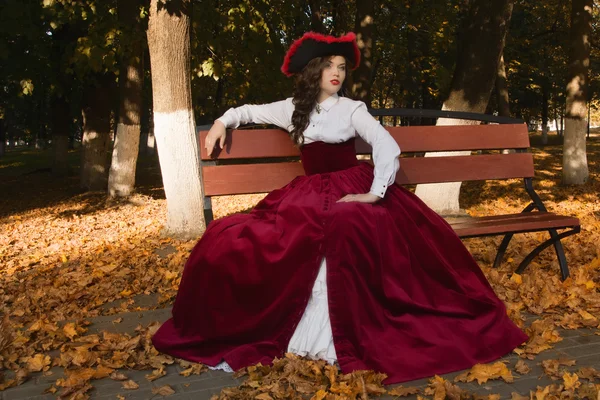 Mulher vestida em um estilo retro no beco de outono — Fotografia de Stock