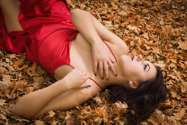 Mädchen im roten Kleid im herbstlichen Wald — Stockfoto