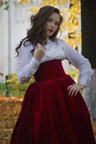 Mujer vestida en un estilo retro en el callejón de otoño — Foto de Stock