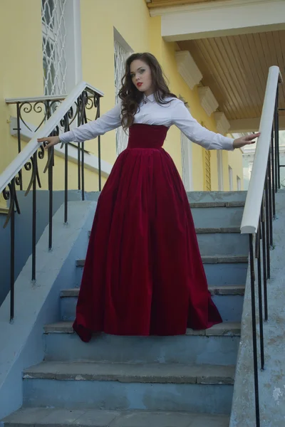 Meisje in vintage jurk op de trap — Stockfoto