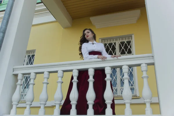 Chica en vestido vintage en el porche de la mansión — Foto de Stock