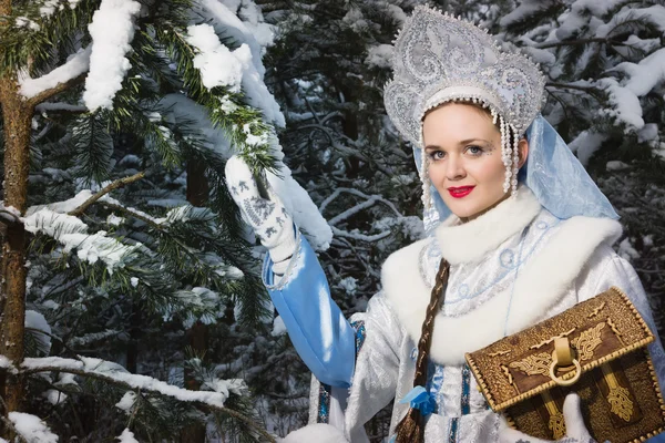 Snegurochka (Snow Maiden) with gifts bag in the winter forest — Stock Photo, Image