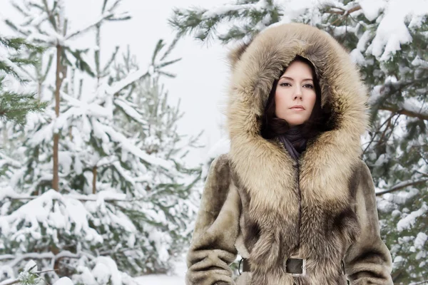 Ung kvinna i skogen vinter — Stockfoto