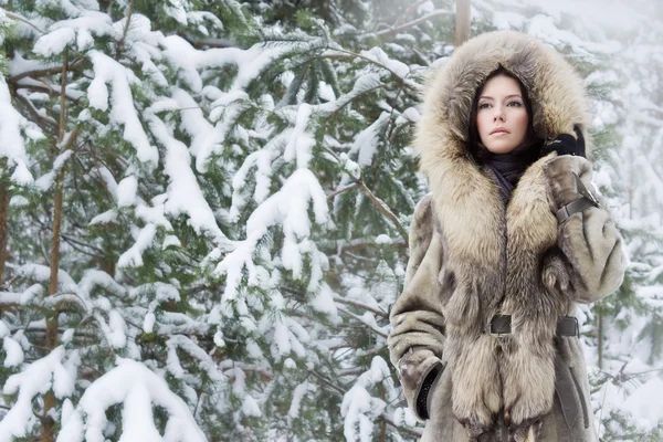 Ung kvinna i skogen vinter — Stockfoto