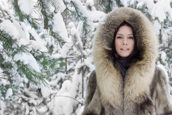 Ung kvinna i skogen vinter — Stockfoto