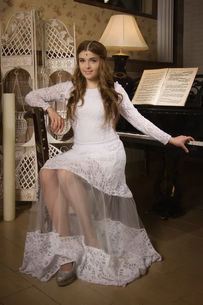 Mujer de belleza en vestido de noche tocando el piano — Foto de Stock