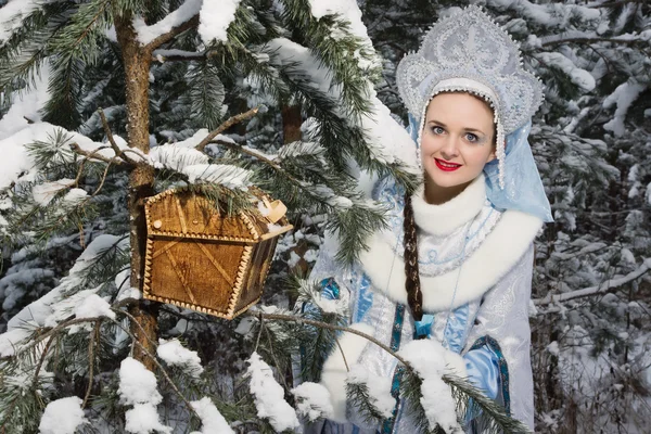 Snegurochka (Snow Maiden) with gifts bag in the winter forest — Stok fotoğraf