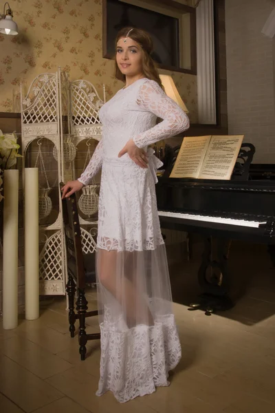 Красавица в вечернем платье играет на пианино — стоковое фото