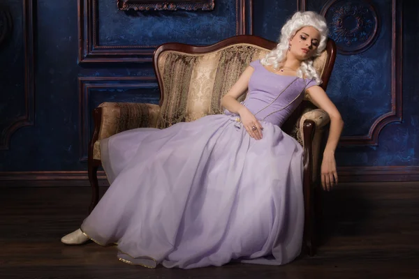 Femme en robe de style baroque historique et perruque blanche sur le canapé — Photo