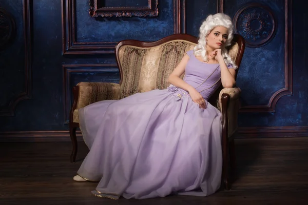 Mulher em estilo barroco histórico vestido e peruca branca no sofá — Fotografia de Stock