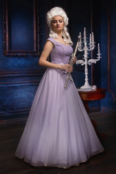Aantrekkelijke jonge vrouwelijke fluitist draagt barokke jurk — Stockfoto