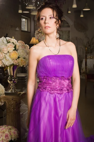 Mooie vrouw gekleed in lange kant jurk in een vintage interio — Stockfoto