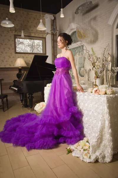 Mulher bonita vestida com vestido de renda longa em um interio vintage — Fotografia de Stock