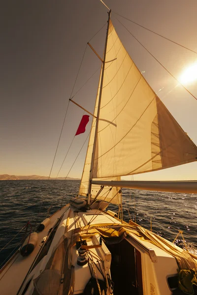 Barco à vela vista de ângulo largo no mar ao pôr do sol — Fotografia de Stock