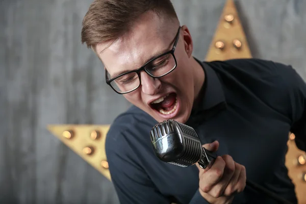 Jongeman zingt met microfoon — Stockfoto