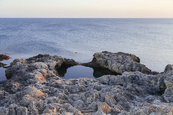 Puesta de sol en la bahía del mar con rocas — Foto de Stock