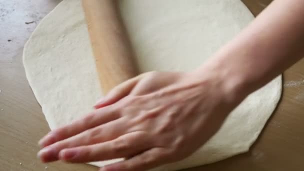 Rolling dough with hands and wooden roller on table — Stock Video