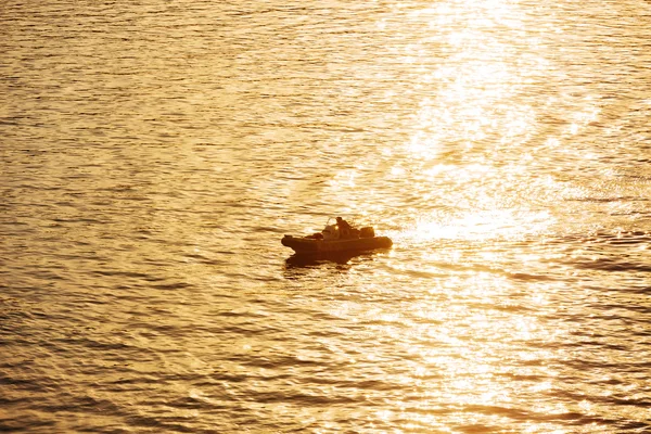 Моторная лодка, плывущая по морю на закате — стоковое фото