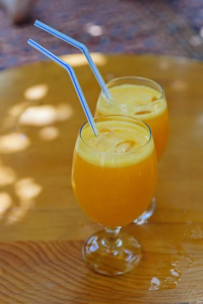 Dos vasos de jugo de naranja con paja de plástico Fotos de stock libres de derechos