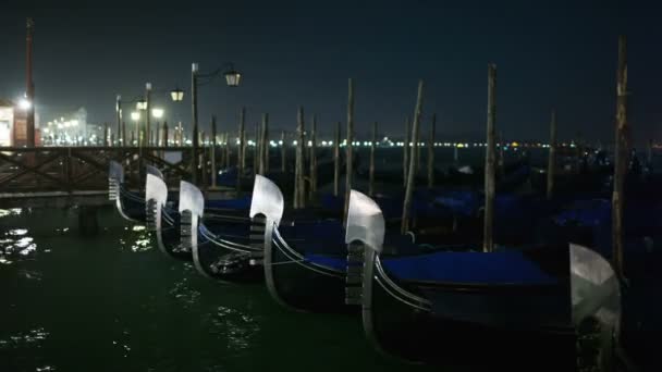 Venetiaanse gondels gebonden in de buurt van de pier bij nacht op het San Marco plein, Venetië, Italië — Stockvideo