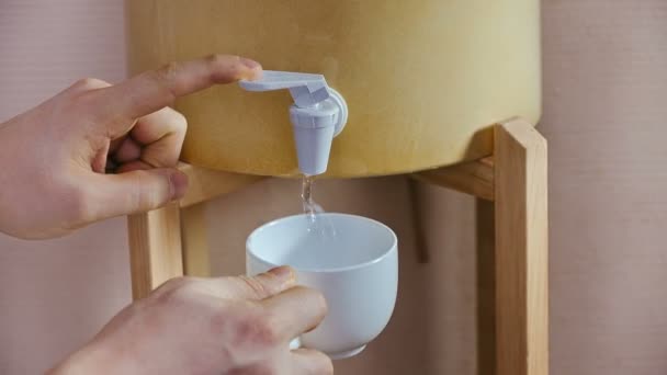 Stromende witte kop met water uit dispenser — Stockvideo