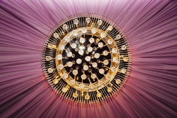 Golden chandelier with violet curtain — Stock Photo, Image