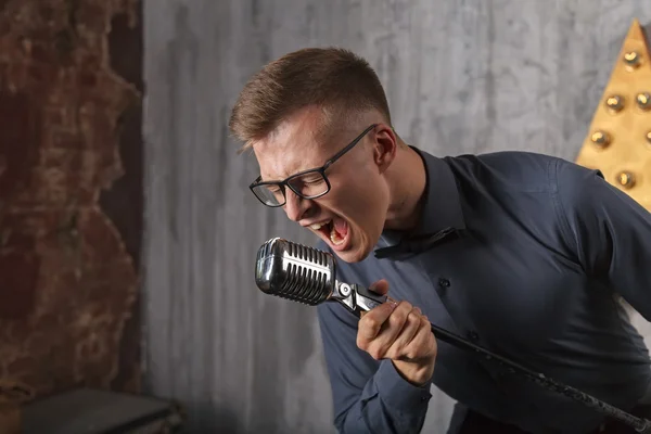 Jongeman zingt met microfoon — Stockfoto