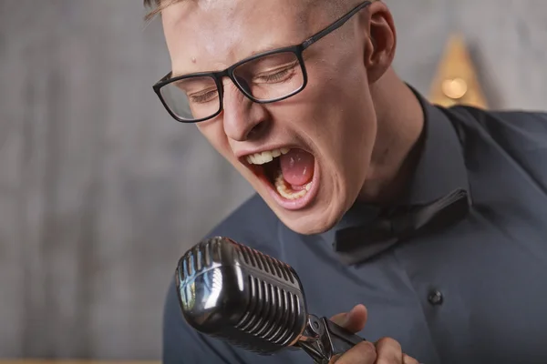 Jongeman zingt met microfoon — Stockfoto