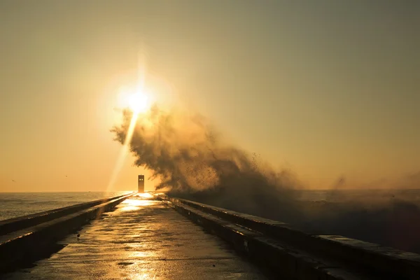 Salpicadura de onda al atardecer cerca del faro — Foto de Stock