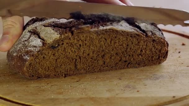 Man snijden roggebrood met lange mes, close-up weergave — Stockvideo