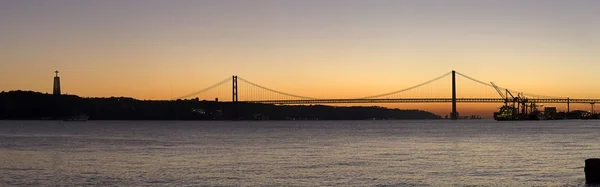 Solnedgången av den 25 april-bron i Lissabon, Portugal — Stockfoto
