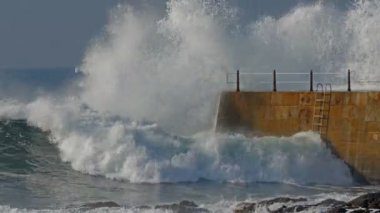Deniz feneri iskele ile dalgalar, güneşli bir gün
