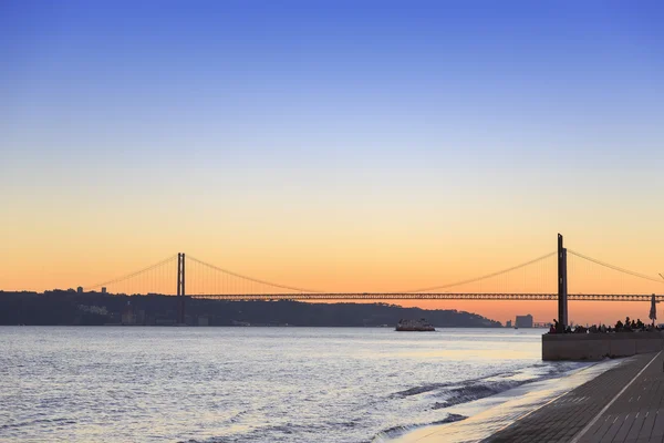 Sonnenuntergang Blick auf die 25 de abril Brücke in Lissabon — Stockfoto