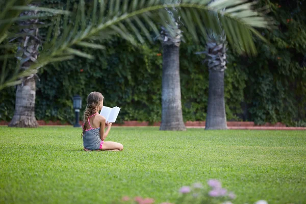 Ragazza stanno leggendo libro a prato verde — Foto Stock