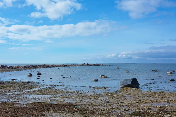 Stenstranden och fläta med en liten fyr — Stockfoto