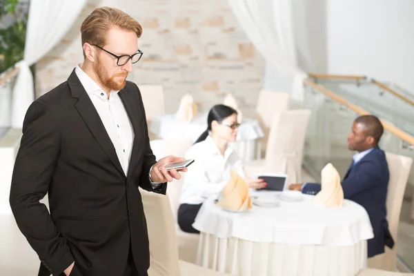 Businessman with mobile phone in restaurant — Stock Photo, Image