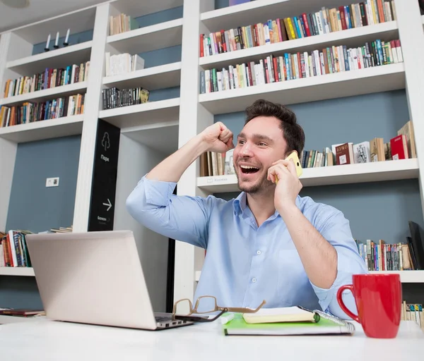 Student speaking over smart phone in library — Stock Photo, Image