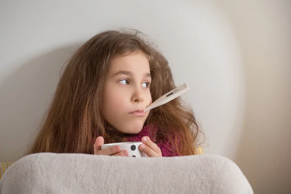 Маленькая девочка с гриппом, простудой или жаром дома — стоковое фото